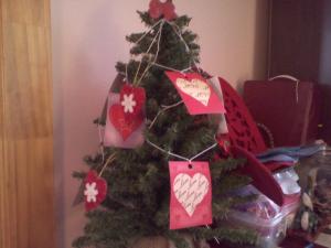 A mini-Christmas tree decorated with paper hearts cut from a gift bag.