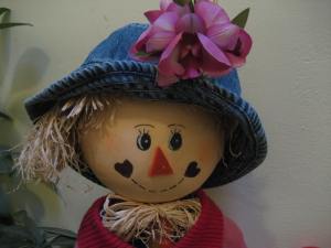 Our scarecrow Rosie, gets a new hat and flower.