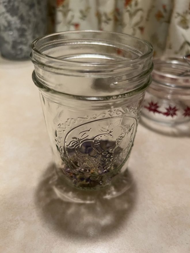 jar of violet flowers sitting on counter