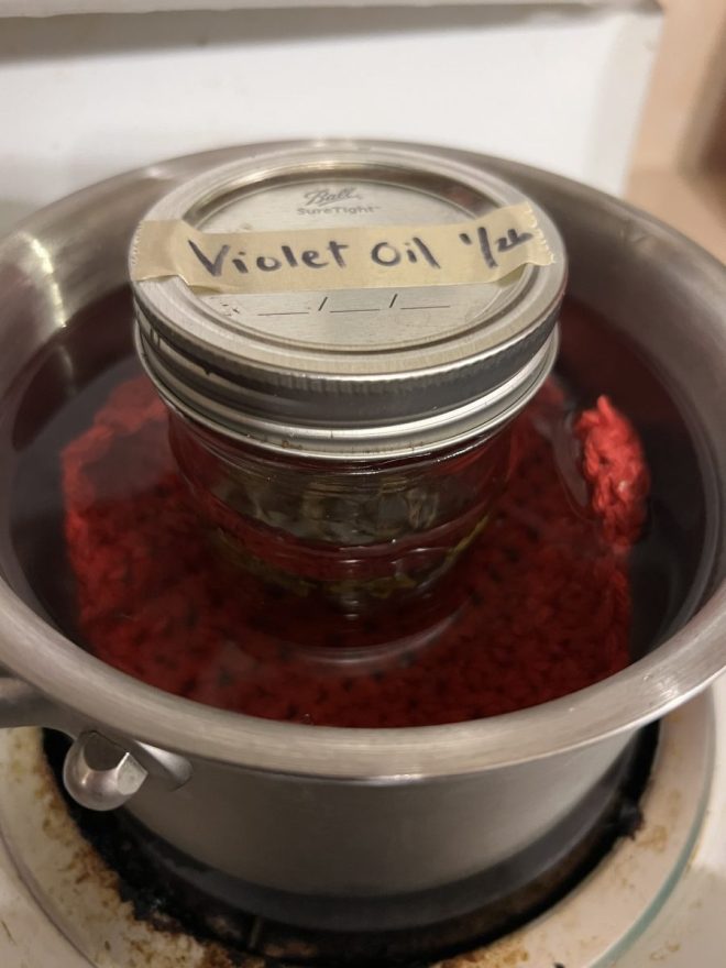 jar of violet oil in sauce pan